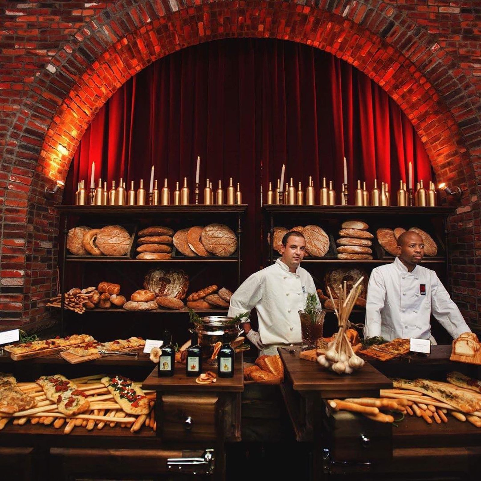 Bakers behind a bread bar under warm light